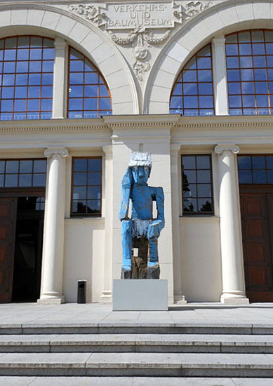 L’entrée du musée d’Art contemporain de Berlin avec la sculpture Volk Ding Zero (« Peuple Chose Zéro ») de Georg Baselitz, 2009, Wikipédia